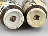 pair of chinese vases with floral designs on them sitting on a table