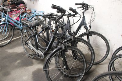 many bikes that are lined up against a wall