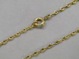 a close up of a gold plated chain on a gray surface