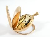 a close up of a pocket watch on a white surface