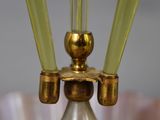 a glass vase with two green candles on top of it
