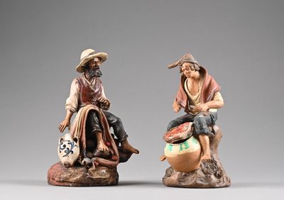 deux figurines d'un homme et d'une femme assis sur un rocher