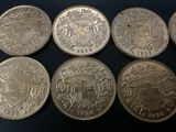 six different types of silver coins on a black surface