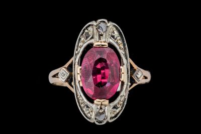 un gros plan d'une bague en pierre rose et diamants sur fond noir