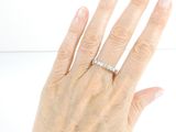 a woman ' s hand with a diamond ring on it