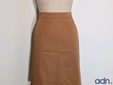 a mannequin with a brown skirt on a mannequin stand