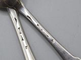 two spoons that are sitting next to each other on a table