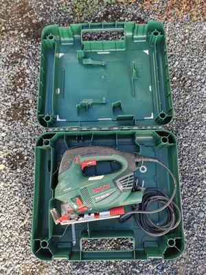 a green box with a corded cord and a tool in it