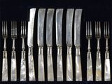 a lot of forks and spoons that are in a case