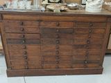 une commode en bois surmontée de nombreux tiroirs