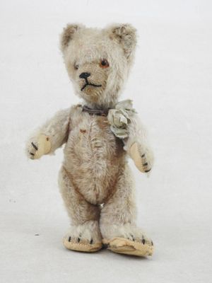 un petit ours en peluche avec un nœud papillon autour du cou