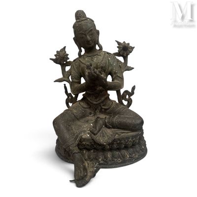 une statue en bronze d'une femme assise sur un rocher