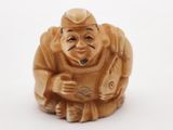 une petite figurine représentant un homme souriant tenant un poisson