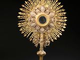 un plat en or richement décoré, surmonté d'une croix