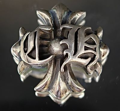 une bague en argent ornée d'une croix, posée sur une table
