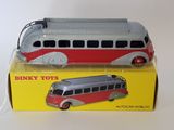 toy bus in a box on a white surface with a yellow box behind it