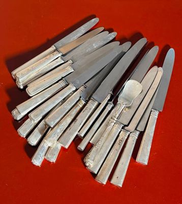 a lot of knives that are sitting on a red table