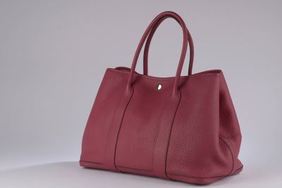a red leather handbag on a white surface