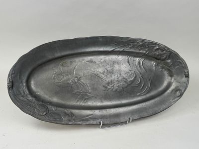 an old silver plate with a lion on it sitting on a white surface