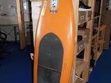 une planche de surf orange exposée dans une pièce