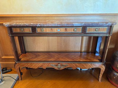 une table en bois avec des tiroirs et une lampe posée dessus