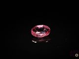 un diamant rose sur une surface noire