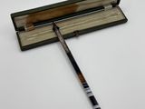 a close up of a pen and a book on a white surface