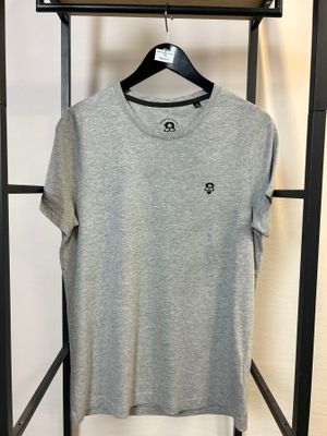 un t-shirt gris suspendu à un portant dans une pièce