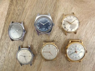 several different types of watches are displayed on a wooden surface