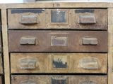 an old chest of drawers with many drawers on top of it