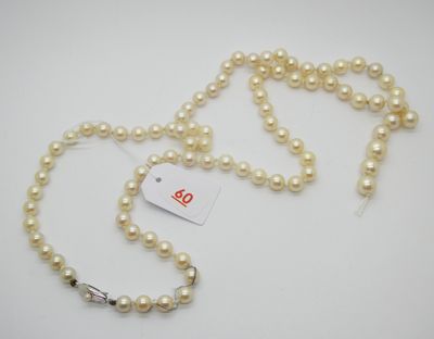 un gros plan sur un collier de perles blanches muni d'une étiquette