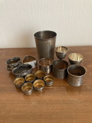 a lot of silver cups sitting on a wooden table