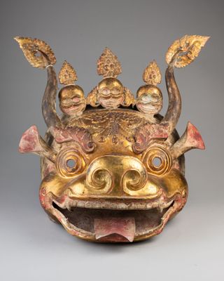 a close up of a gold mask on a gray background