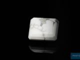 une photo d'un bloc de marbre blanc posé sur une surface noire