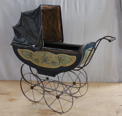 an old fashioned baby carriage with a black seat and a black cover