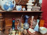 a wooden shelf with many different vases and dishes on it