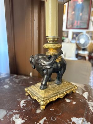 an elephant statue on top of a table next to a lamp