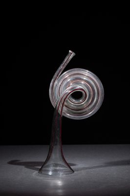a glass sculpture of a spiral shaped object on a table