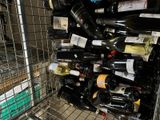 many bottles of wine in a metal rack in a store