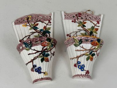 paire de vases blancs ornés de fleurs et de vrilles sur un fond blanc