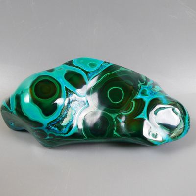 sculpture en verre vert et noir représentant un poisson sur un fond blanc