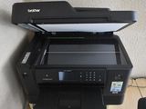 a printer sitting on top of a desk next to a chair