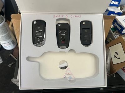 une boîte contenant trois télécommandes, posée sur une table
