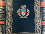 a black book with gold trim and a crest on it