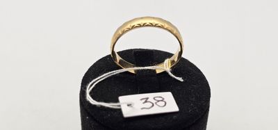 un gros plan d'une bague en or posée sur un présentoir noir
