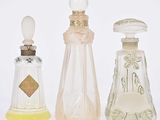 Trois types différents de flacons de parfum sont alignés sur une surface blanche