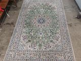an oriental rug on the ground with a chair and a table in the background