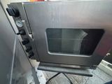 a silver oven that is sitting on a stand