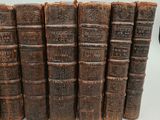 several old books are stacked on top of each other on a table