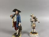 deux figurines représentant un homme et une femme vêtus de costumes coloniaux
